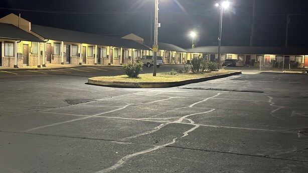 A parking lot with a building in the background. - Interstate Inn Express (Tulsa)