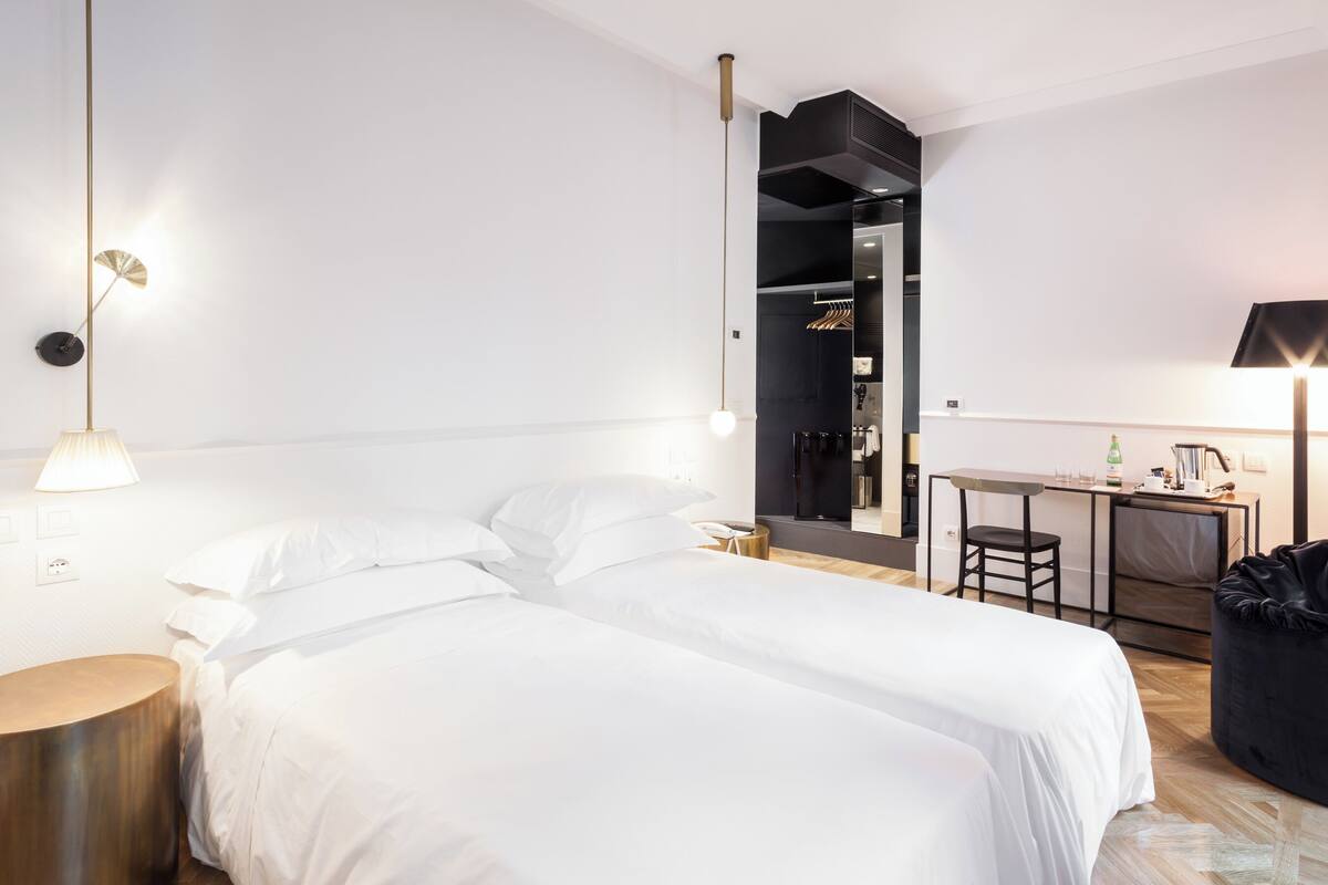 Habitació d'hotel moderna amb un llit gran, una taula de treball i una zona de seients.
