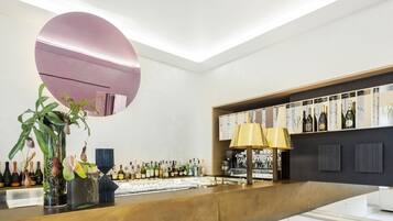 A modern bar area with a large mirror, a variety of bottles, and a decorative plant.