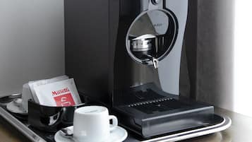 Una macchina del caffè con una tazza e una confezione di caffè su un vassoio.