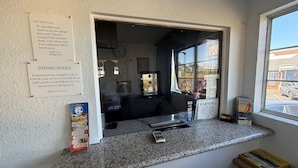 Ein Tresen mit Quittung, einer Uhr und einem Fenster mit Blick ins Freie.