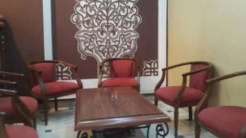 Un salón de conferencias con una mesa de madera y seis sillas tapizadas rojas.