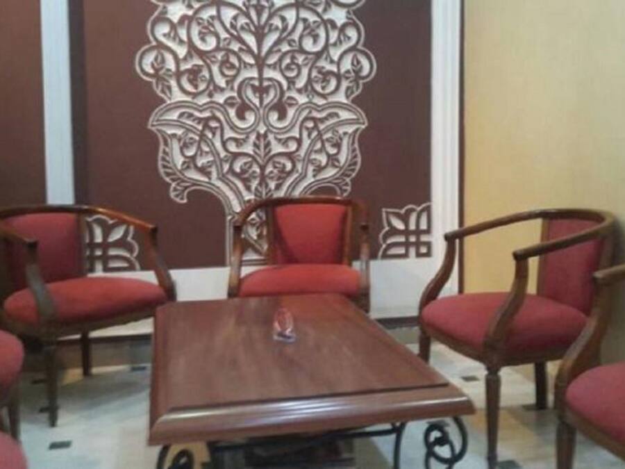 Un salón de conferencias con una mesa de madera y seis sillas tapizadas rojas.
