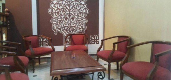 A conference room with a wooden table and six red upholstered chairs. - Hotel Roza (Algiers)