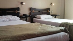 Two single beds with wooden headboards, white linens, and bedside lamps. - Hotel Roza (Algiers)