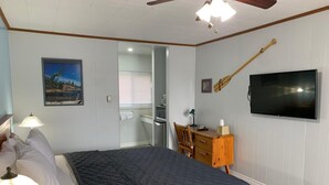 A bedroom with a bed, a desk, a chair, a television, and a ceiling fan. - Town and Country Motel (Parry Sound)