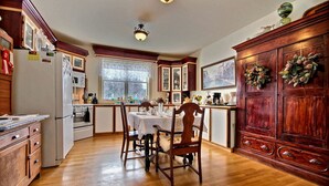 Una cocina con armarios de madera, una mesa de comedor y un refrigerador.