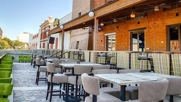 An outdoor seating area with brick buildings and a clear sky. - Hard Rock Hotel & Casino Sioux City (Sioux City)