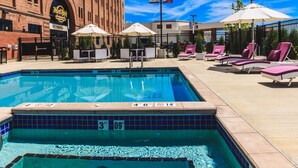 A swimming pool with lounge chairs and umbrellas, a Hard Rock Cafe sign, and a clear blue sky. - Hard Rock Hotel & Casino Sioux City (Sioux City)