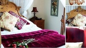 Un dormitorio con una cama de madera, una colcha morada y una mesita de noche con lámpara.