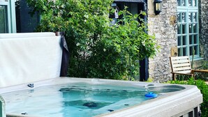 Un edificio de piedra con un jacuzzi al frente.