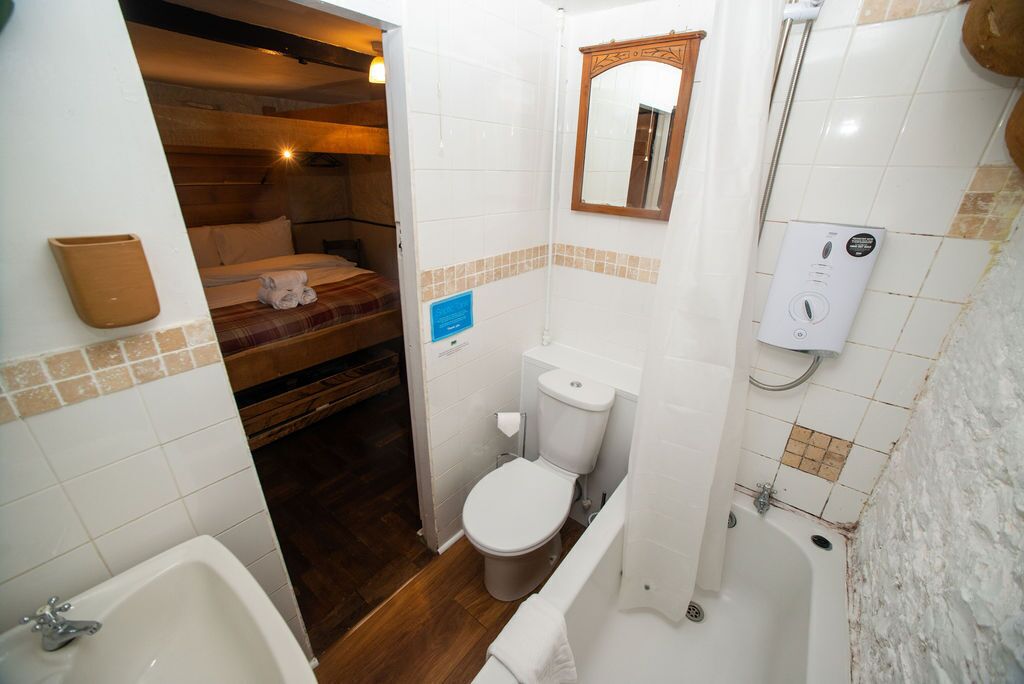 Un baño compacto con inodoro, bañera y una pequeña zona de ducha.