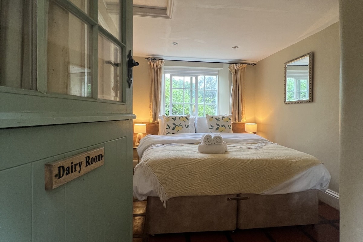 A room with a bed, a dresser, and a window.