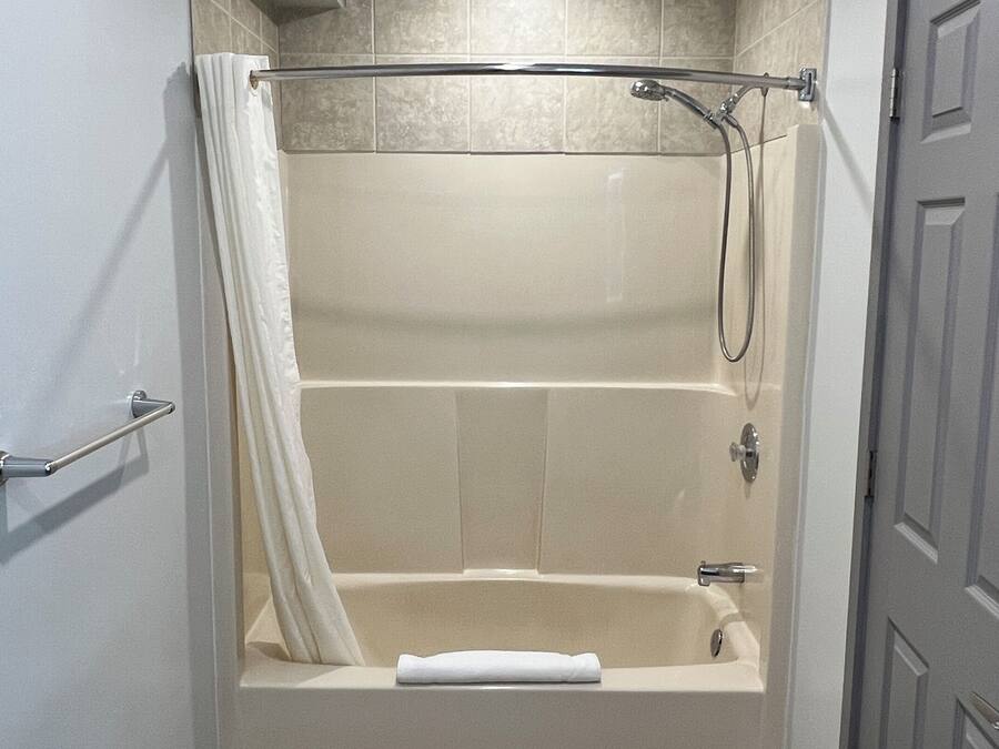 Un baño con bañera, ducha y retrete.