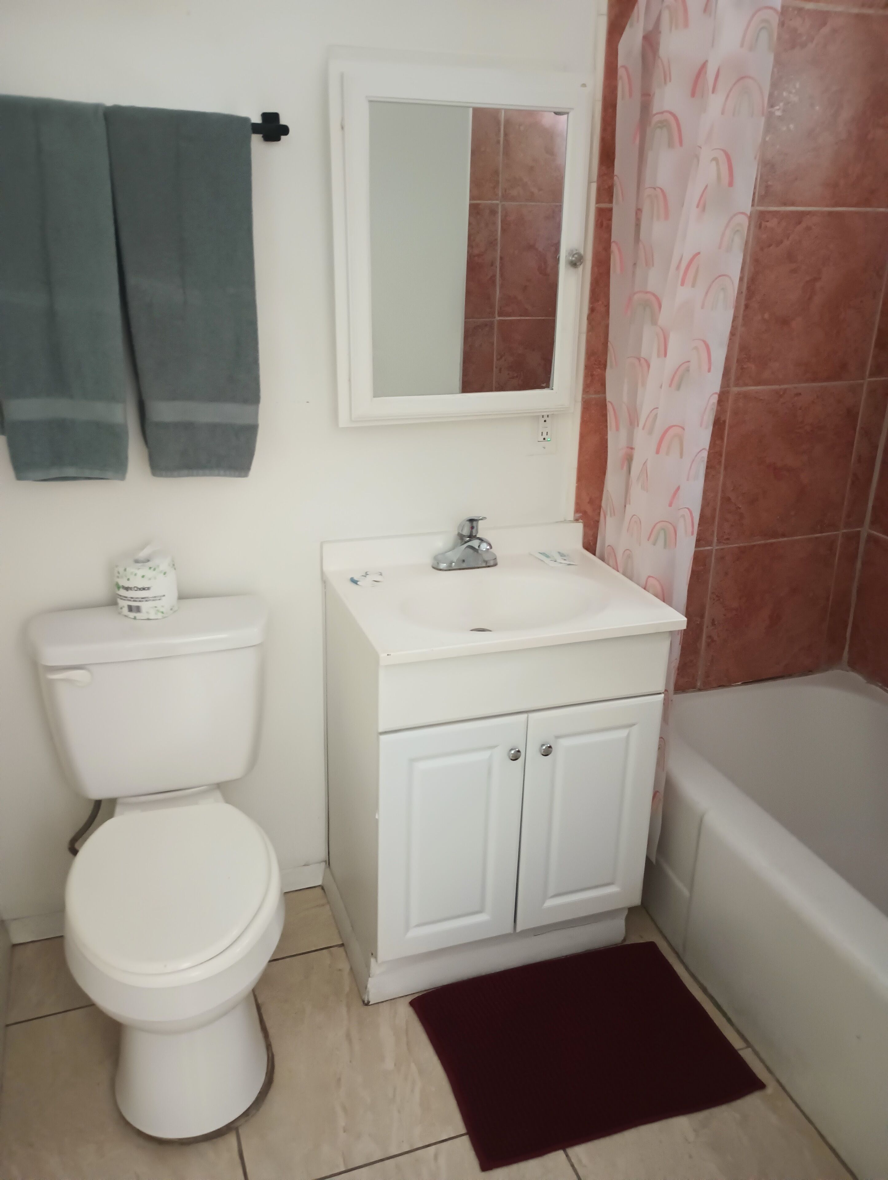 Een badkamer met toilet, wastafel en bad.
