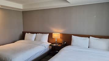 Ein Hotelzimmer mit zwei Betten, einem Nachttisch mit Lampe und einem Telefon.