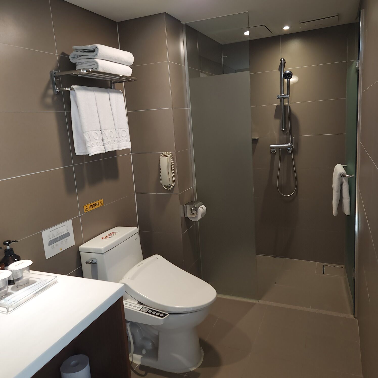 Un baño moderno con inodoro, ducha y lavamanos.
