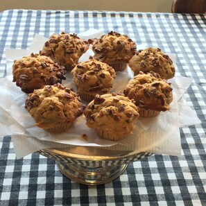 A metal bowl containing six muffins on a checkered tablecloth. - Pisgah View Ranch (Candler)