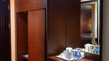 Habitación con armario empotrado, espejo y una pequeña zona de tocador con tetera y tazas.