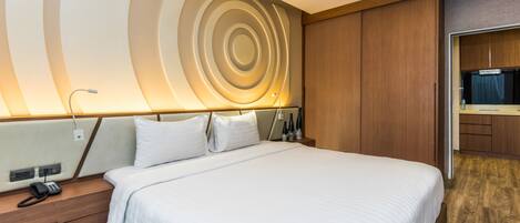 Una habitación de hotel moderna con una cama grande, cabecera de madera y un diseño de pared circular único.
