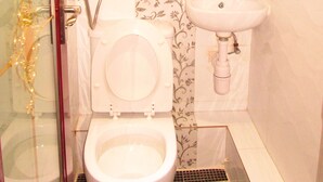 A bathroom with a toilet, a sink, and a shower unit. - New Reliance Inn (Kowloon)