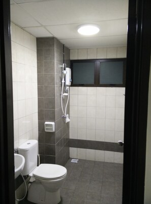 A small, tiled bathroom with a toilet, sink, and shower. - Indah Alam Vacation Home (Shah Alam)