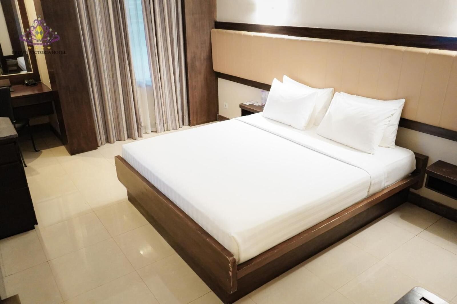 Habitación de hotel con una cama grande, un escritorio y una silla.