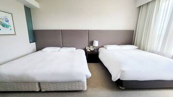Une chambre d’hôtel avec deux lits, une table de chevet, une lampe et un tableau encadré au mur.