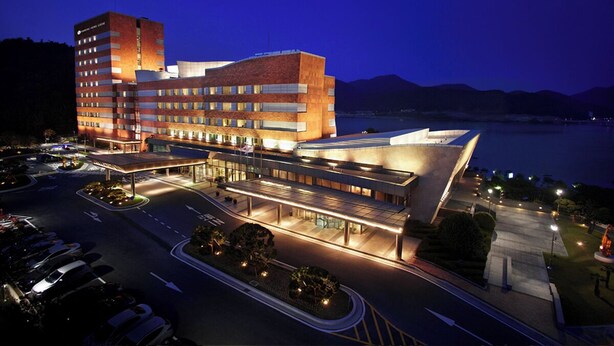 A modern hotel with a curved facade, multiple floors, and a parking area. - Samsung Hotel Geoje (Geoje)