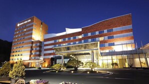 A multi-story hotel with a modern design, featuring a prominent entrance and a well-lit facade. - Samsung Hotel Geoje (Geoje)
