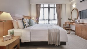 A hotel room with a large bed, bedside tables, a desk with a chair, a TV, and a window with curtains. - Village Residence Clarke Quay (Singapore)
