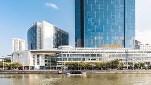 A modern building with a glass facade, a waterfront view, and a sign that reads "Central". - Village Residence Clarke Quay (Singapore)