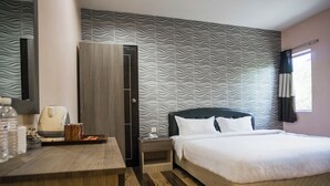 A hotel room with a bed, a desk, a wardrobe, and a patterned wall. - Sky Star Hotel at KLIA KLIA2 (Sepang)