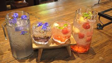 Three glasses of iced beverages on a wooden table.