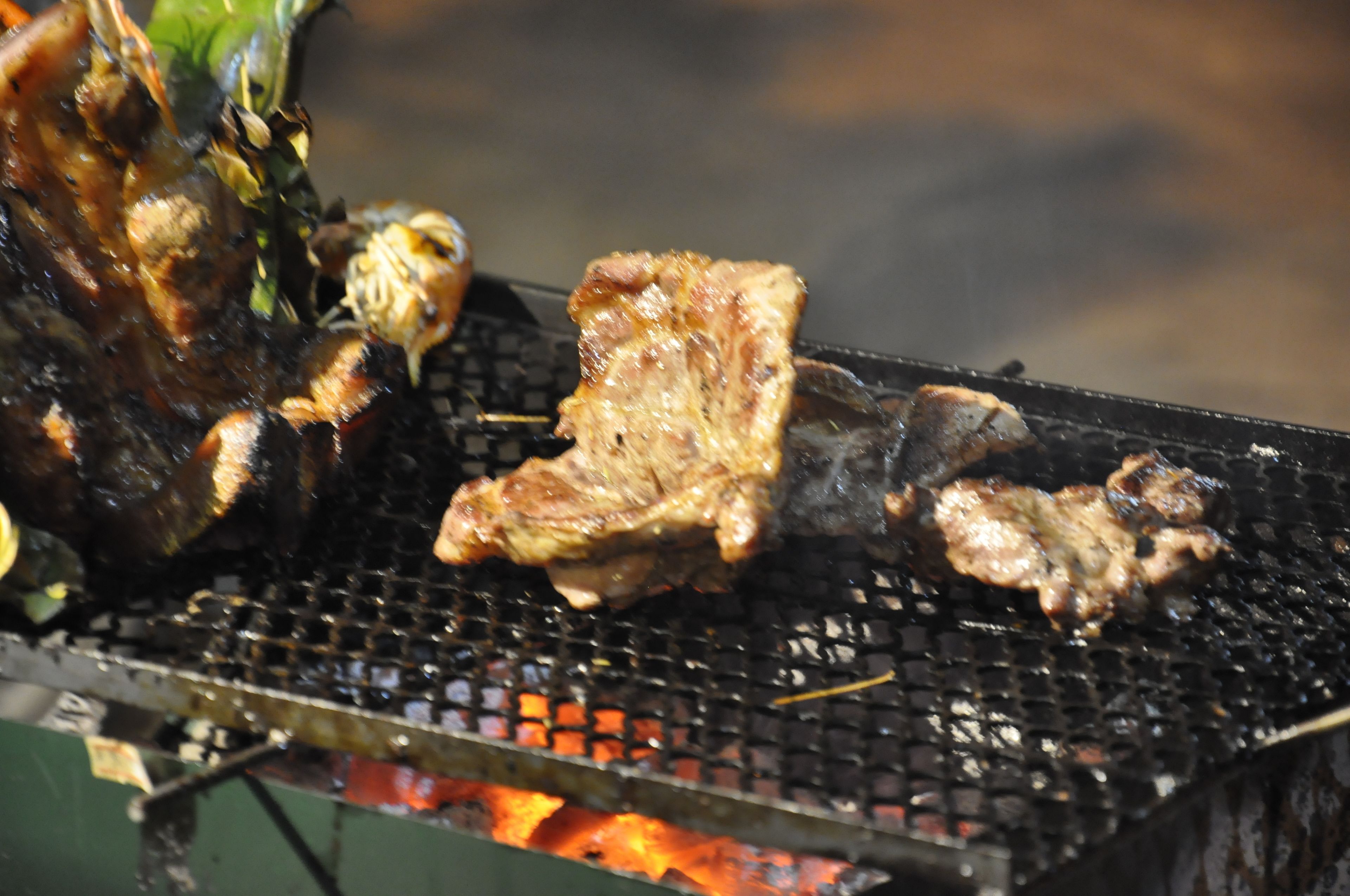 A grill with various meats being cooked.