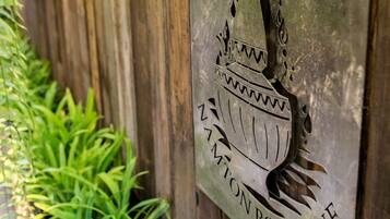 A wooden wall with a metal plaque that reads "NANTON BOUTIQUE" and decorative metal elements.