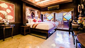 Une chambre traditionnelle avec un grand lit, des meubles en bois et une vue par la fenêtre.