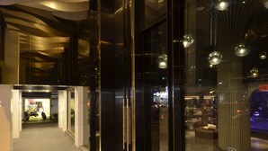 Entrada de un edificio moderno con puertas de vidrio, una rampa y un cartel de Starhaus.