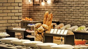 A buffet setup with various food items and a brick wall background.