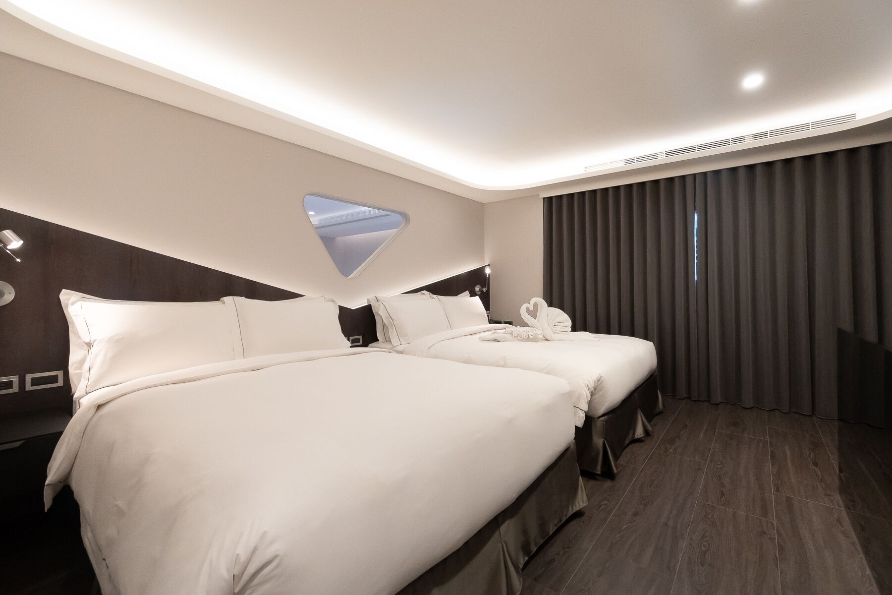 Une chambre d’hôtel avec deux lits, une grande fenêtre et une vue sur le ciel.