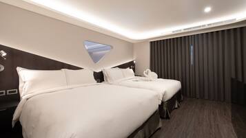 Une chambre d’hôtel avec deux lits, une grande fenêtre et une vue sur le ciel.
