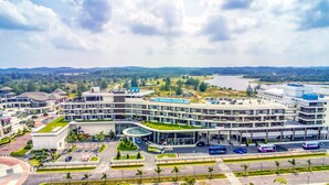 A modern hotel with a central courtyard, multiple floors, and a view of a lake.