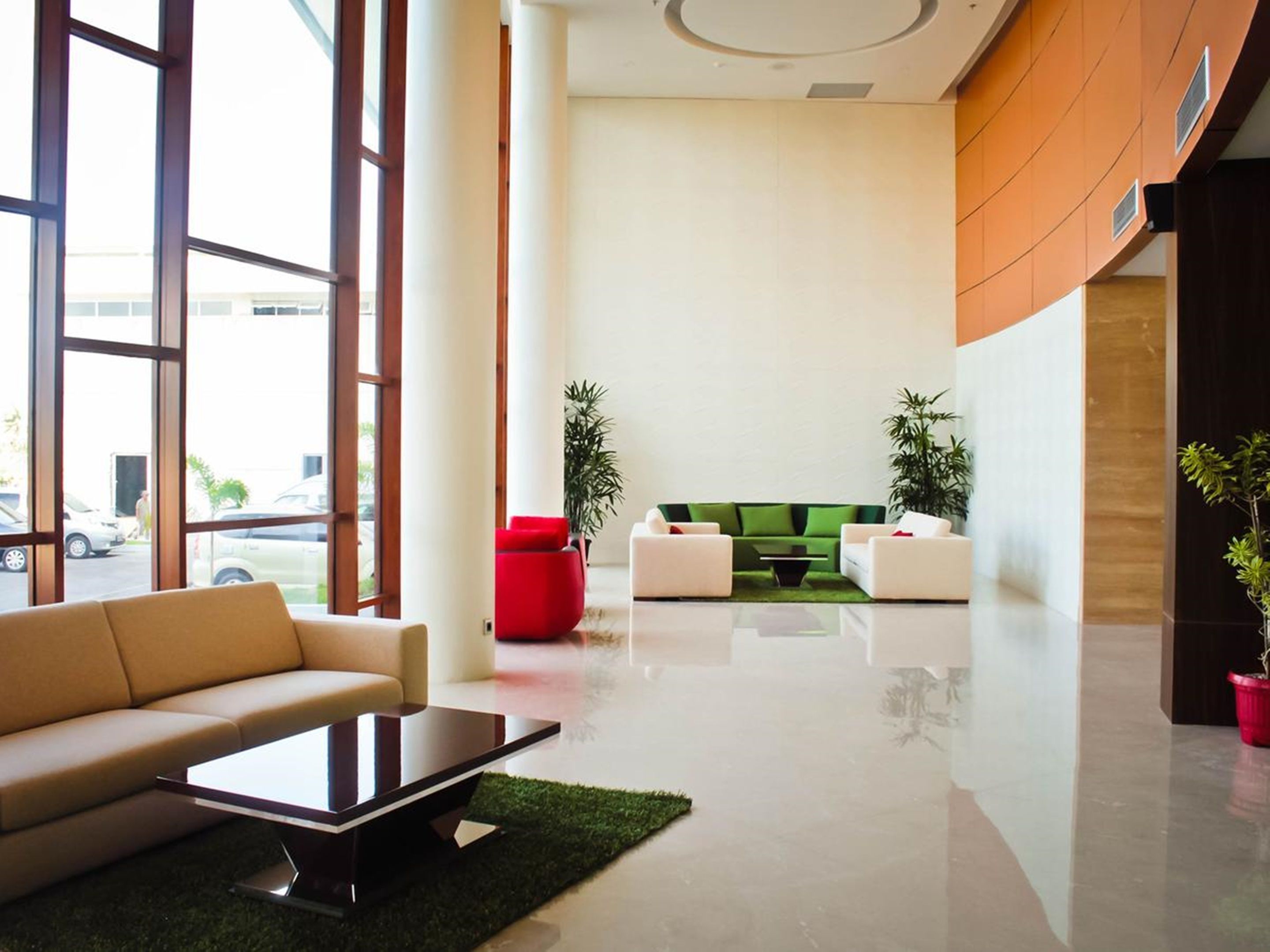 A modern lobby with a sofa, coffee table, and two armchairs.