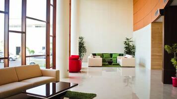 A modern lobby with a sofa, coffee table, and two armchairs.