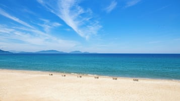 Am Strand, weißer Sandstrand, Liegestühle, Sonnenschirme