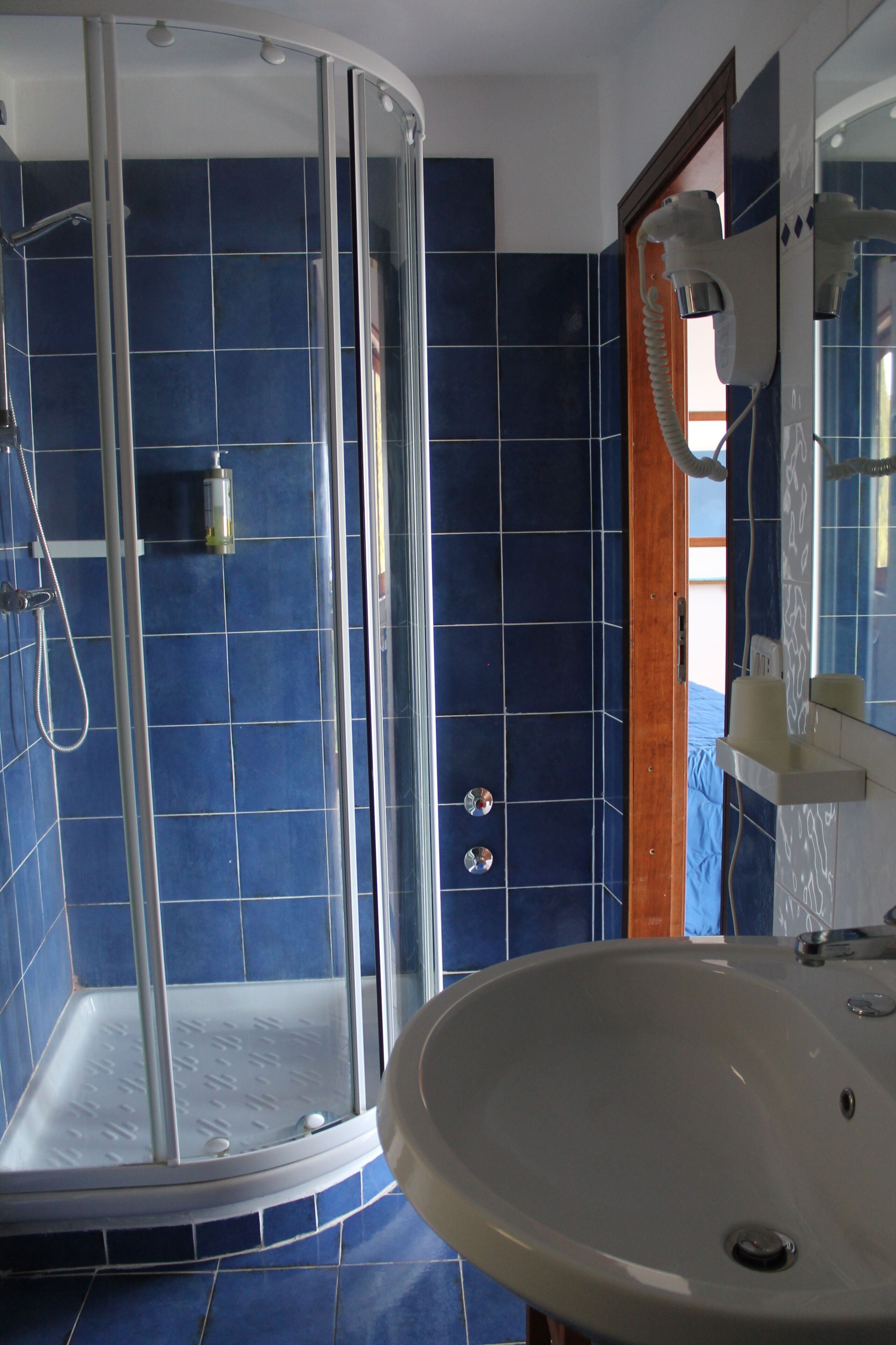 A bathroom with a shower, a sink, and a mirror.