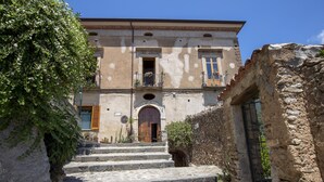 A stone staircase leading to a building with a wooden door and a balcony. - La Casa sul Blu Albergo Diffuso (Pisciotta)