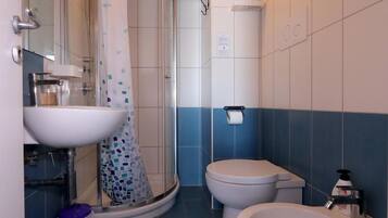 A bathroom with a sink, toilet, and shower.