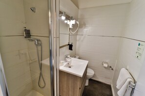 Une salle de bain équipée d’une douche, de toilettes, d’un lavabo et d’un porte-serviettes.