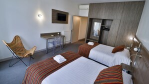 A hotel room with two beds, a desk, a chair, a TV, and a mirror. - Hôtel de l'Europe Grenoble Hyper Centre (Grenoble)
